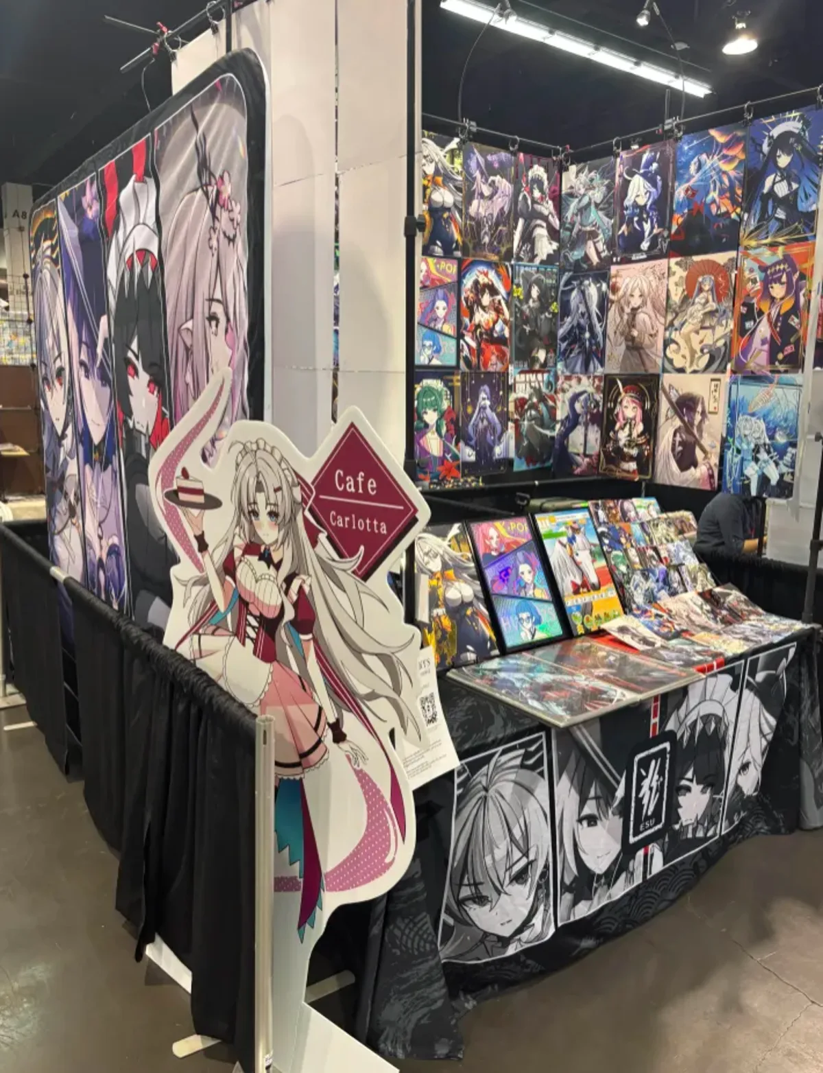 Convention booth corner with print wall and standee